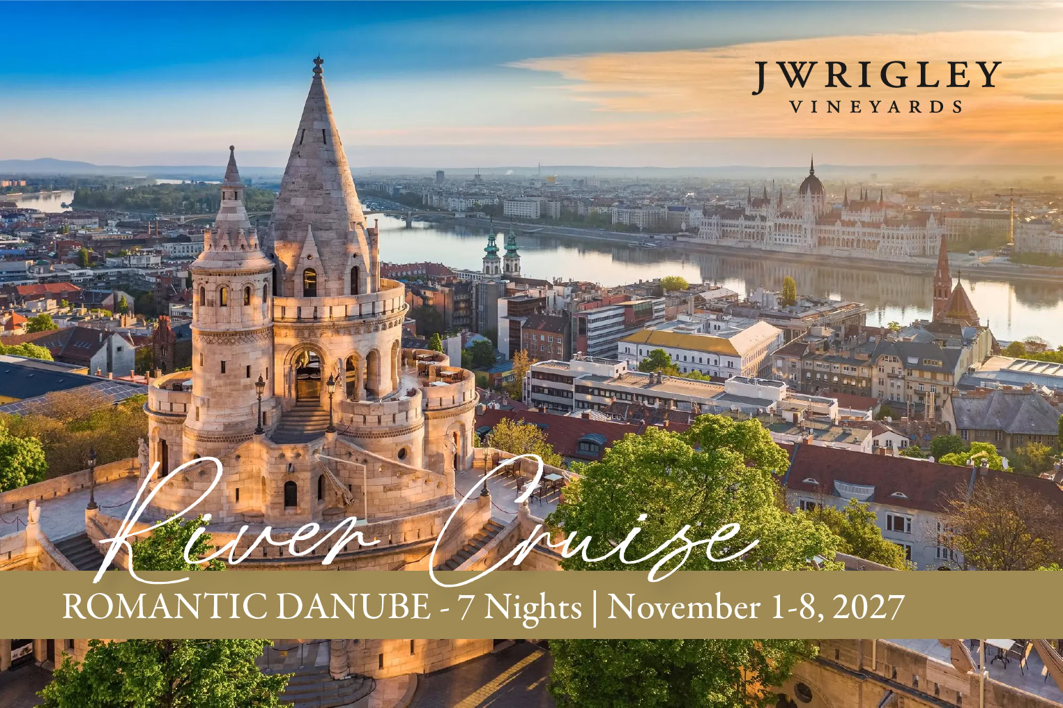 J Wrigley Vineyards logo over Budapest skyline with Fisherman's Bastion and Danube River at sunset.